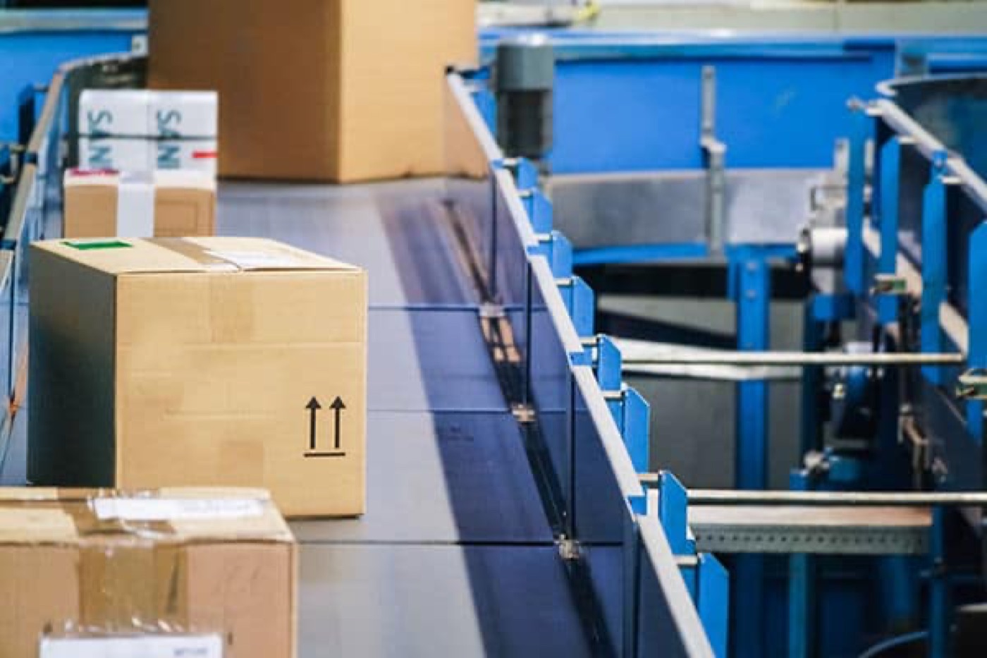 Colis suivis par vidéosurveillance sur un convoyeur de centre logistique